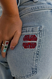 Deloris Whistle Ring with colourful gemstones and a chunky silver finish, styled with embroidered denim jeans.