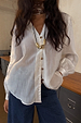 White Miley Shirt with tortoise buttons and blouson sleeves, styled with dark blue jeans and a gold necklace.