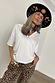 Thumbnail for White cotton T-shirt with shoulder pads and a deep V-neck, styled with leopard print trousers and a patterned hat.