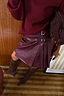 Thumbnail for Burgundy vegan leather mini kilt skirt with side buckle fastenings and pleated detailing.