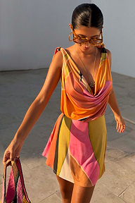 Yellow Tort Wiggle Arm Sunglasses with light yellow tortoise frames and blue lenses, paired with a colourful print dress.