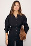 Thumbnail for Black Zoe Shirt featuring a cinched waist seam, button-down front and puffed sleeves, styled with a brown bag.