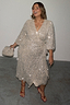 Silver Sequin Kira Wrap Dress with a tie fastening, styled with red heels and shown in UK size 18 for inclusive sizing.