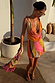 Abstract Beaded Fringe Bag with multicoloured glass beads and pink tassels, held by a model in a matching mini dress.