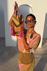 Abstract Beaded Fringe Bag with green glass beads and pink tassels, held by a model in a coordinated plissé dress.