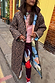 Thumbnail for Reversible longline leopard print coat with a quilted navy abstract side, styled in a London street setting.