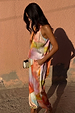 Abstract Lily Top in a multi-coloured print, styled as a multi-wear co-ord set against a pink wall.