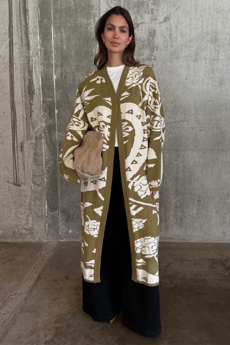 Olive Amara Knit Coatigan featuring cream eye and heart motifs, styled with black wide-leg trousers.
