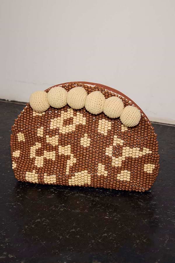 Jaden Beaded Clutch Bag featuring brown and cream leopard print beading and large cream crochet pom-poms.