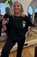 Black Sweatshirt with Ecru Embroidery featuring palm and heart motifs, styled in an oversized fit on a smiling woman.