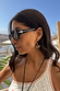 Black Studded Acetate Sunglasses with silver detailing and branding, worn by a model in an outdoor vacation setting.