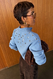 Ice Blue Studded Cardigan with silver metal studs on the back and sleeves, shown from a side view.