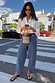 Thumbnail for Blue Studded Barrel Jeans with side studs and a structured barrel leg, styled with a white shirt.
