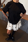 Black Bow Back T-Shirt in a relaxed fit with dropped shoulders, paired with a white bow-detail mini skirt.