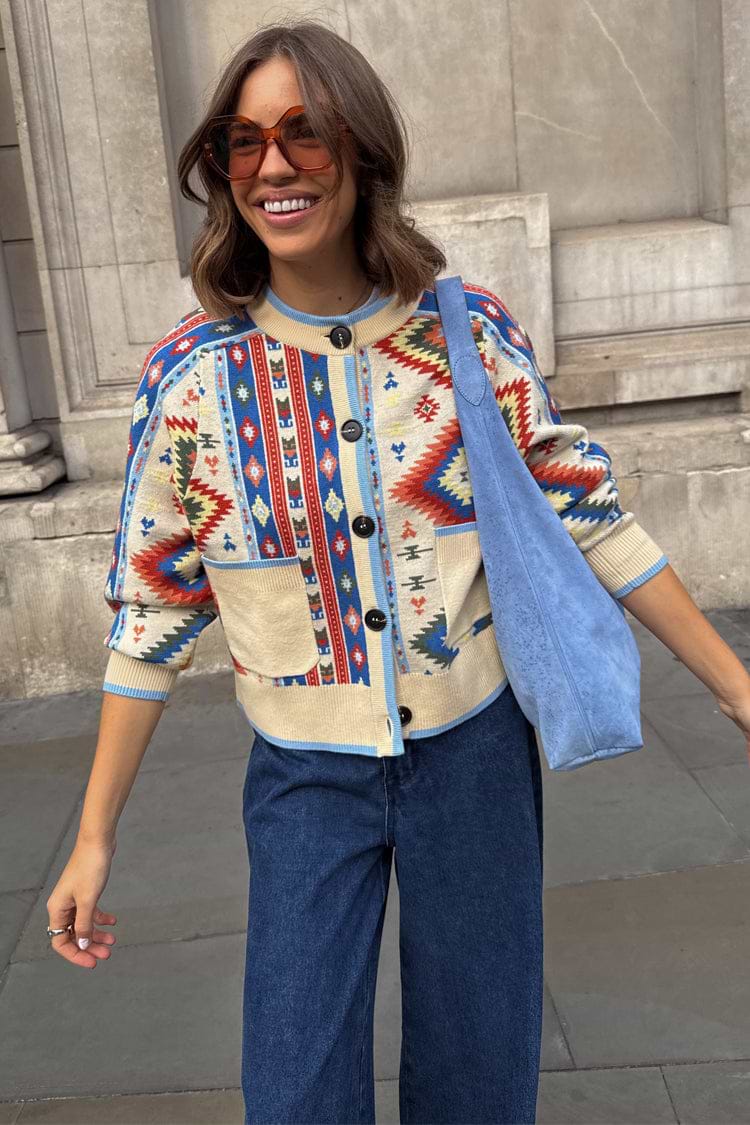 Bridget Cheryl Cardigan with blue and orange geometric motifs on a cream knit, styled with jeans for London looks.
