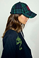 Navy and green tartan cap with red NFD logo embroidery, worn with a pinstripe blazer with snake detail.