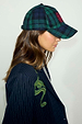 Navy and green tartan cap with red NFD logo embroidery, worn with a pinstripe blazer with snake detail.