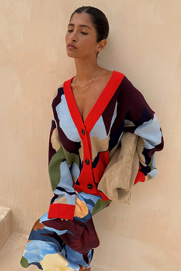 Navy Abstract Callie Cardigan in an iconic artist print with red ribbed trims and button-up front on a model.
