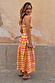 Check Lola Mid-axi Dress in yellow, pink and orange with a ruched bodice and cotton skirt, shown on a model.
