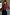 Thumbnail for Cherry Mesh Long Sleeve Top in red sheer mesh with a cherry print, paired with black trousers and a brown bag.