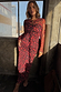 Thumbnail for Red Cherry Mesh Soho Dress with a digital cherry print and long sleeves, worn by a model in an industrial setting.