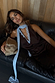 Chocolate Blue Lace Top featuring light blue lace trim and neck ties, shown on a model lounging on a leather sofa.