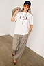 White cotton Cowboy Boot T-Shirt with a relaxed fit and multicoloured boot motifs, styled with check trousers.