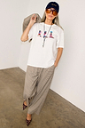 White cotton Cowboy Boot T-Shirt with a relaxed fit and multicoloured boot motifs, styled with check trousers.