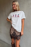 White boxy Cowboy Boot T-Shirt with colourful motifs, paired with a leopard print lace-trim mini skirt.