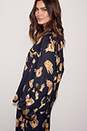 Deloris Button Through Pyjamas in black featuring gold hand and heart motifs, worn by a model looking over her shoulder.