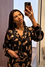 Deloris Button Through Pyjamas in black with iconic NFD motifs and gold piping, shown in a mirror selfie.