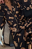 Deloris Button Through Pyjamas in black with gold hand, heart and eye motifs and contrast piping.