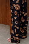 Deloris Button Through Pyjama bottoms in black, showcasing the gold hand, heart and eye print with piped hems.