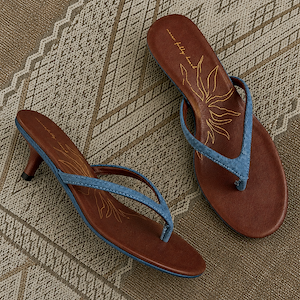 Denim Sandal Mules featuring slim blue straps, a low sculpted kitten heel, and brown cushioned soles with a sun motif.
