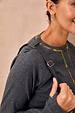 Charcoal Life is Tough Honey Drainage Bag strap worn over a grey ribbed top with vibrant rainbow stitching.