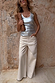 Ecru Jan Jeans with a wide palazzo leg, styled with a silver metallic top and leopard print clutch bag.