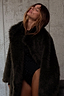 Thumbnail for Green Faux Fur Coat with a relaxed silhouette, worn over a black bodysuit on a model.