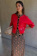 Red Cherry Holly Cardigan featuring leopard trim and cherry motifs, styled over a leopard print dress.