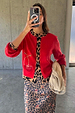 Red knit Cherry Holly Cardigan with wide sleeves, leopard print trim and cherry motifs, over a leopard skirt.