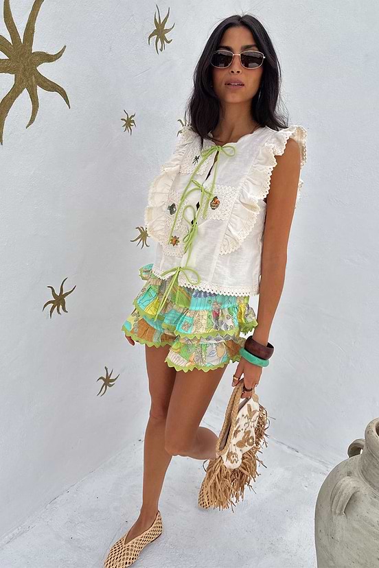 Isla Ruffle Shorts with tiered detailing and lace trim in a hand-painted print, paired with a white tie-front top.