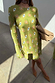 Khaki Eye Mini Soho Dress Petite featuring an iconic eye print and flared sleeves, styled with a tan clutch.