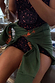 Khaki sweatshirt with orange embroidered motifs tied at the waist over a leopard print activewear set.