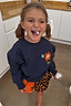 Thumbnail for Kids Navy Charms Sweatshirt featuring colourful sun and star motifs, worn by a laughing girl in pigtails.