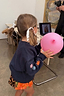 Thumbnail for Kids Navy Charms Sweatshirt with colorful sun and star sleeve embroidery, worn by a child holding a pink balloon.