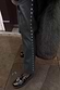 Thumbnail for Bottle green vegan leather trousers with silver side studs, styled with black buckled shoes on a stone pavement.