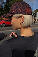 Dark Leopard Cap in iconic leopard print with burgundy tones and embroidered logo, styled on a model in a London street.