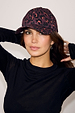 Dark Leopard Cap in an iconic burgundy animal print, worn by a model in a black long-sleeved top.