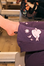 Orange cotton crew sock with leopard print detail worn with embroidered purple trousers in a gym.