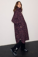 Dark Leopard Rain Mac in a waterproof fabric with an iconic animal print, relaxed fit and side pockets on a model.