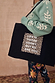 Black canvas tote featuring iconic leopard print and motivational text, carried over the shoulder by a model.